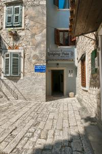 a stone alley with a building with a sign on it at Hostel Pula in Pula