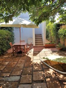 a patio with a table and an umbrella at Villa dei Gelsi in Villaggio Resta