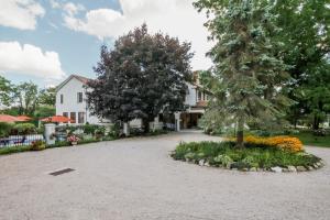 a driveway in front of a house with trees and flowers at The Villa Bed and Breakfast in Westerly