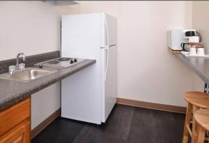 a kitchen with a white refrigerator and a sink at Americas Best Value Inn & Suites; Atlantic Inn & Suites in Atlantic
