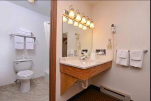 a bathroom with a sink and a toilet and a mirror at Americas Best Value Inn & Suites; Atlantic Inn & Suites in Atlantic