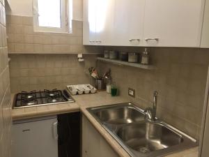 a kitchen with a sink and a stove at Napoli Plebiscito Apartment in Naples +23 photos