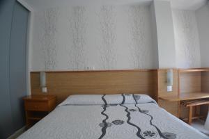 波多諾伏的住宿－卡薩瑪麗亞旅館，一间卧室配有一张床、一张桌子和一张四柱床。