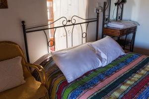 a bed with a pillow sitting next to a window at Hatzikyprianou Museum Studio in Lazania