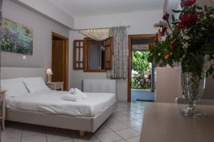 a bedroom with a bed and a table with a vase of flowers at Aloni Studios & Apartments in Athanion
