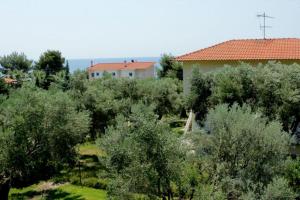 ein Haus und Bäume vor einem Haus in der Unterkunft Petradaki Apartments in Mola Kaliva