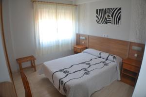 sypialnia z dużym łóżkiem i oknem w obiekcie Hostal Casa Maria w mieście Portonovo