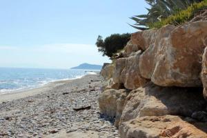 a group of rocks on a beach near the ocean at Petradaki Apartments in Mola Kalyva