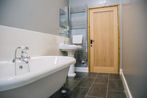 a bathroom with a tub and a toilet and a sink at Fieldsview in Wrexham