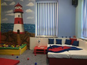 a bedroom with a bed and a lighthouse painted on the wall at Family Paradise Huslenky in Huslenky