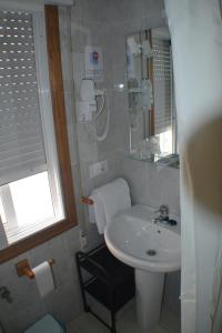 mała łazienka z umywalką i lustrem w obiekcie Hostal Casa Maria w mieście Portonovo