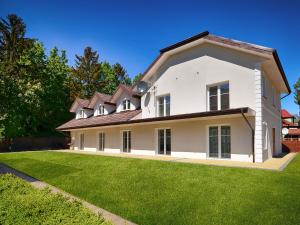 a large white house with a large yard at Apartamenty Mariner in Darłówko