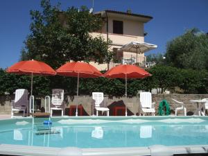 a swimming pool with umbrellas and chairs and a building at B&B La Casa Di Zefiro in Limite