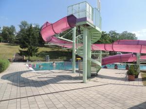 a water slide in a pool with people in it at Haus Trappiste FOR FAMILIES ONLY NON SMOKING !! AIRCO ! in Donnerskirchen