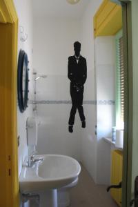 アルバ・アドリアティカにあるOstello La Stazioneの壁に男性の写真が飾られたバスルーム