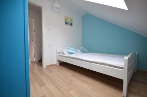 a small bed in a room with a staircase at Apartamenty Mariner in Darłówko