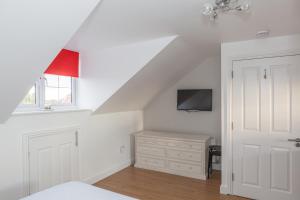 a white bedroom with a bed and a dresser and a window at Park View Studio - Lydiard Millicent Swindon Wiltshire in Swindon