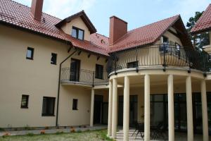 ein großes Haus mit Säulen und einem Dach in der Unterkunft Villa Dolce Vita in Mrzeżyno