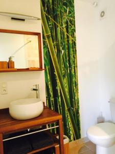 y baño con lavabo y cortina de ducha de bambú. en L'Islo Bamboo, en Saumane-de-Vaucluse