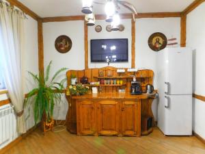 a kitchen with a refrigerator and a tv on the wall at Glanz in Yaremche