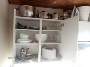 a kitchen cabinet filled with dishes and pots and pans at The coolest baby penthouse in Oostende in Ostend