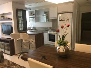 uma cozinha com uma mesa com um vaso de flores em Apartamento - Balneário Camboriú em Balneário Camboriú