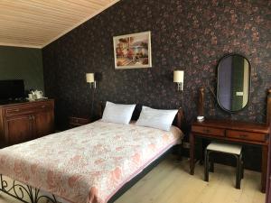 a bedroom with a bed, chair and a lamp at Minihotel Zolotoe Runo in Ploskoye