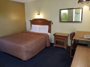 Habitación de hotel con cama y espejo en Rodeway Inn en La Crosse