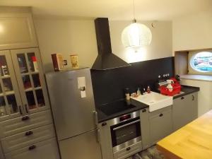 a kitchen with a stainless steel refrigerator and a sink at La Vue De Château in Commercy