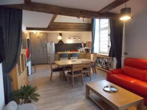 a living room with a red couch and a table at La Vue De Château in Commercy