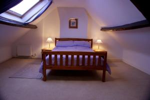a bedroom with a bed and two lamps on two tables at Lupine Cottage in Whitby