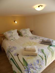Un dormitorio con una gran cama blanca con flores. en La Vue De Château en Commercy