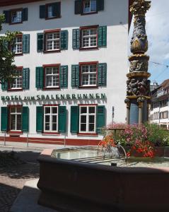 ein Gebäude mit einem Brunnen vor einem Gebäude in der Unterkunft Spalenbrunnen Hotel & Restaurant Basel City Center in Basel