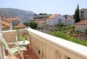 un balcón con una mesa y un jarrón de flores en Rooms Franica, en Dubrovnik