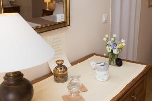 une table avec une lampe et un vase de fleurs sur elle dans l'établissement La Boudrie, à Avranches
