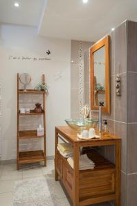 a bathroom with a glass sink and a mirror at La Boudrie in Avranches