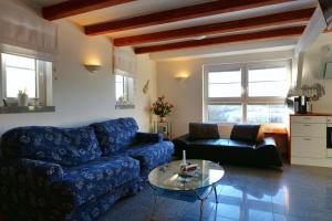 ein Wohnzimmer mit einem blauen Sofa und einem Tisch in der Unterkunft Gesindehaus Charis in Kippenheim