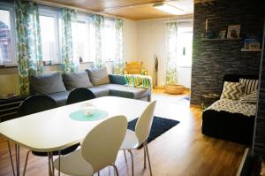 a living room with a couch and a table and chairs at Åker Kristinagården in Skillingaryd