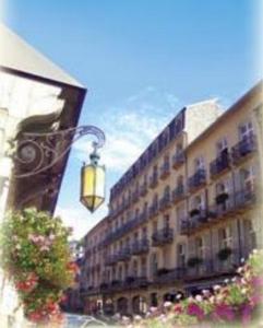 a street light in front of a building with flowers at Residence des Bains in Plombières-les-Bains