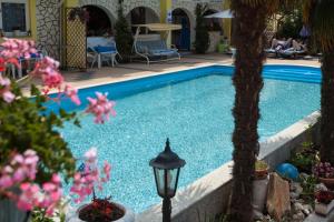 a swimming pool with a street light and flowers at Apartments Paradis in Rovinj +8 photos