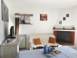 a living room with a couch and a tv at Azienda Multifunzionale S'Ozastro in Santa Marinella