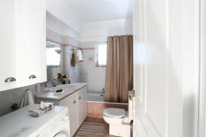 un bagno bianco con un water e un lavandino di Unique Flat with Sea View at Edem Beach - A Seafront Property by Athenian Homes ad Atene