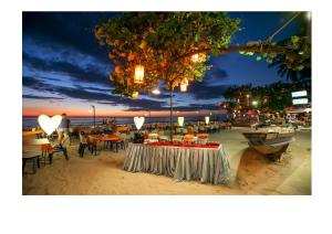 a table with food on a beach at night at Mac Resort Hotel in Ko Chang