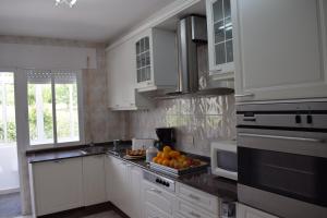 a kitchen with white cabinets and oranges on the counter at La Casa de Manuel in Portomarin