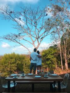 Un uomo e una donna in piedi a un tavolo di El Respiro Ecolodge a Granada