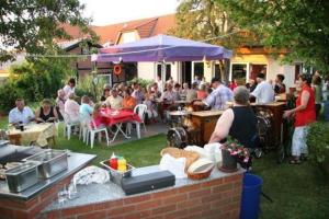 een groep mensen die aan tafels in een tuin zitten bij Gasthaus Zum Rethberg in Lübstorf