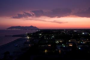 a city at night with a mountain in the background at Torre Del Sole in Terracina