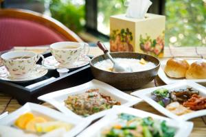 a table topped with plates of food and bowls of food at Maison-Philo Homestay B & B in Sanyi