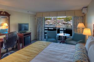 Habitación de hotel con cama, escritorio y TV. en Browns Wharf Inn, en Boothbay Harbor