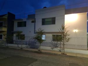 un bâtiment blanc avec une clôture à côté d'une rue dans l'établissement Casa RyS Hotel, à Ocotlán